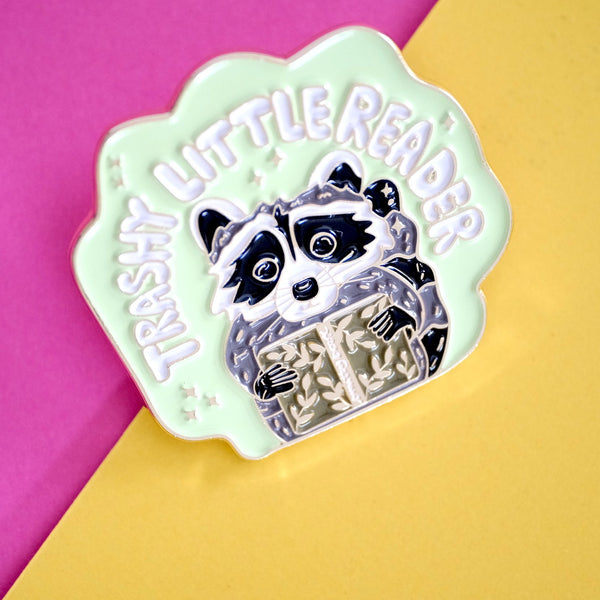 611fc05e3c4ce80992caae23_trashy-little-reader-racoon-pin-3_1790864758936.jpg