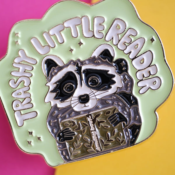 611fc05e3c4ce80992caae23_trashy-little-reader-racoon-pin-4_1790814033379.jpg